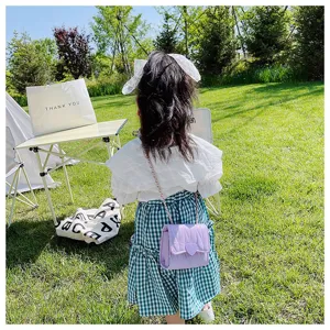Little girl wearing a cute purple quilted chain bag with heart buckle outdoors