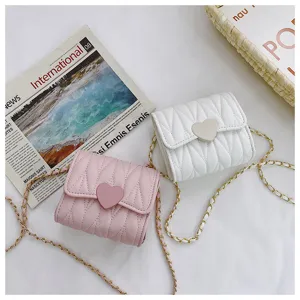 Detailed view of quilted heart-shaped mini chain purses for little girls in pink and white