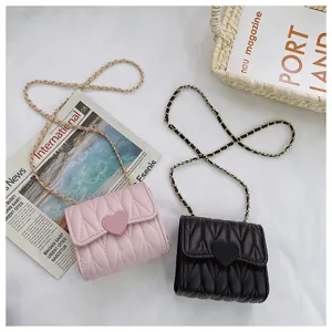 Detailed view of quilted mini chain crossbody bags with heart clasp in pink and black