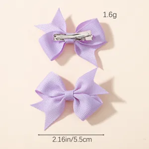 Close-up of purple grosgrain ribbon bow hair clips showing front and back details