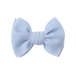 Primo piano di un fermaglio per capelli a fiocco in tessuto azzurro per bambini