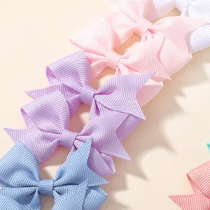 Macro detail of colorful grosgrain ribbon hair bows in soft pastel shades for children