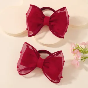 Close-up of red children's mesh bow hair ties featuring a delicate polka dot texture