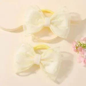 Close-up of cream mesh bow hair ties for children with soft ribbon detail