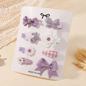 Detailed view of adorable purple bow and floral hair clip set for girls on a white display card