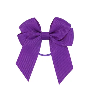 Dettaglio di un fiocco per capelli in nastro viola con nastri a doppio strato lunghi
