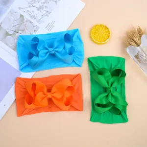 Soft nylon baby headbands with oversized bows in bright blue, orange, and green colors.