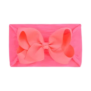 Ultra-soft fluorescent pink nylon baby headband with a large coral ribbed bow for infants