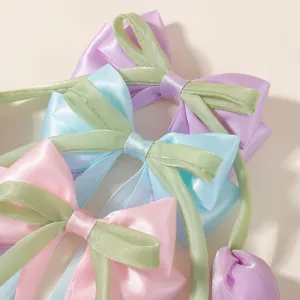 Detalle de pinzas para el cabello con lazo de satén pastel y cintas de tulipán verdes