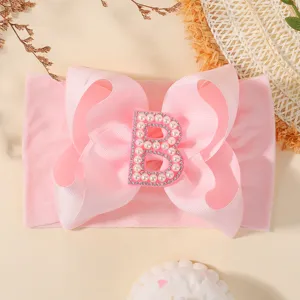 Bandeau rose pour bébé avec un grand nœud et un motif de lettre B serti de perles