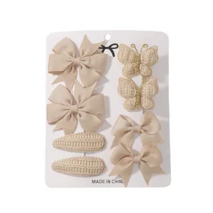 Set of 8 beige children hair clips featuring ribbon bows and knitted butterflies