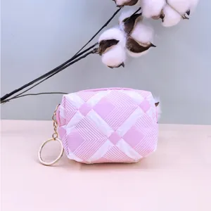 Detailansicht einer süßen rosa-weißen gesteppten Münztasche mit Schlüsselring als Accessoire.