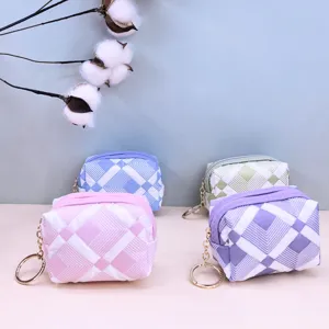 Nahaufnahme des süßen gesteppten Karo-Münzbeutels mit Metallschlüsselanhänger, Stofftasche.