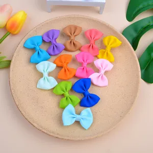 Assorted colorful grosgrain ribbon bow hair clips for kids displayed on a ceramic plate