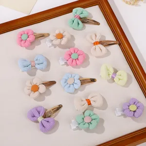 Detailed view of assorted fabric flower and bow hair clips for kids in lovely pastel colors