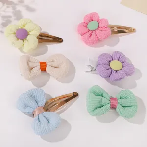 Detail showing pastel corduroy fabric flower and bow hair clips with metal snap