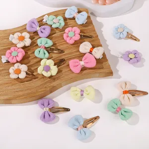 Macro detail of colorful mini corduroy flower and bow hair clips for baby girls.
