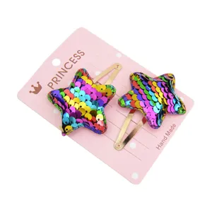Detail view of two colorful gradient sequin star hair clips on pink display card