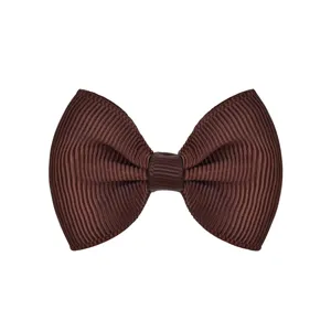 Macro detail view of a solid brown ribbed grosgrain bow hair clip for toddlers