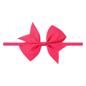 Vue détaillée d'un nœud en ruban gros-grain rose vif sur un bandeau bébé élastique.