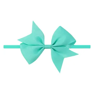 Détail d'un nœud en ruban gros-grain vert menthe sur un bandeau pour bébé élastique