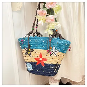 Close-up detail of colorful woven tote bag with 3D floral accents and beaded rope handles