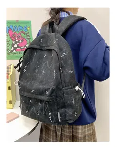 Detail of a black student backpack with white lightning patterns worn in a lifestyle setting