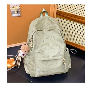 Detail of light green student backpack with silver lightning bolt embroidery and bear charm