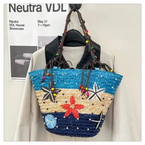 Detailed view of color block woven tote bag with flower motifs and beaded handles
