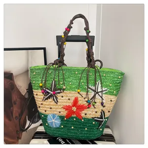 Detailed view of handmade woven straw tote with colorful floral accents and beads