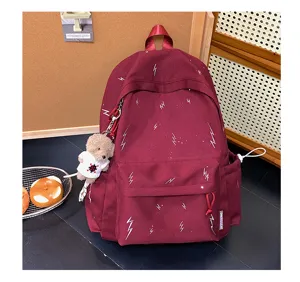 Burgundy high-capacity school backpack with white lightning print and cute teddy bear charm