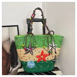 Detailed view of woven straw basket bag with floral decorations and color blocks