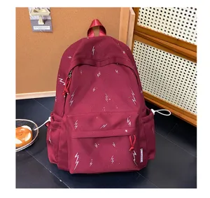 Detailed macro view of the white lightning pattern on the burgundy backpack fabric.