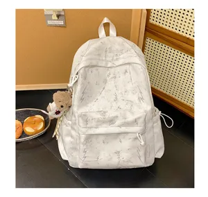 Detailed view of white backpack with lightning patterns and a cute bear charm