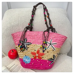 Detailed view of a colorful woven straw tote bag with floral accents and beaded straps.