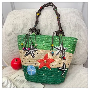 Detail of a colorful woven tote bag with 3D floral appliques and beaded rope handles