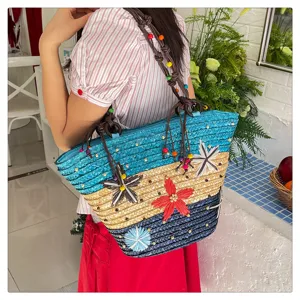 Handwoven straw tote bag with colorful flower motifs and beaded straps for women.