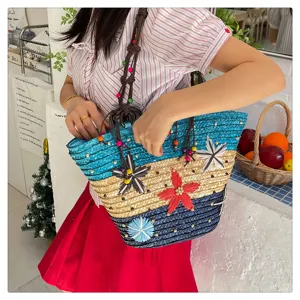 Detail shot of a colorful woven tote bag with flower appliques carried by a model.
