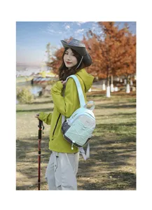 Outdoor lifestyle shot of a woman wearing a mint green color-block hiking backpack