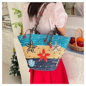 Detailed view of a large woven tote bag with colorful flower accents and wooden beads.