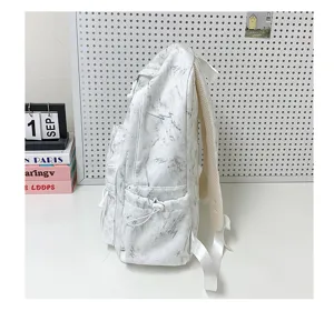 Side view detail of a white marble lightning print backpack showing adjustable side pocket
