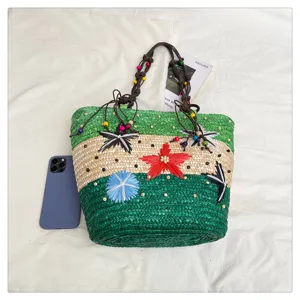 Detailed view of multicolor woven straw basket tote bag with floral accents and beaded straps