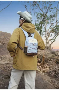 Female model wearing a stylish color-block mini backpack in an outdoor hiking scenery