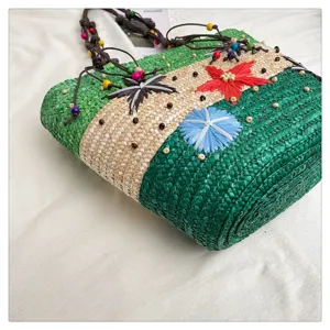 Detailed macro view of vibrant woven straw bag with colorful floral embroidery