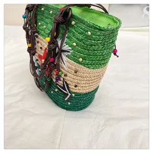 Close-up of vibrant green woven straw tote bag with colorful bead and flower accents