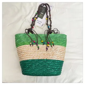 Multi-color woven straw tote bag featuring beaded rope handles and color-block design