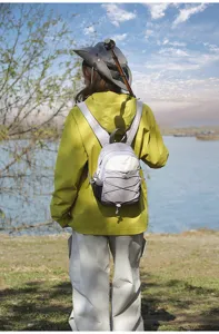 Detailed back view of a small color-blocked hiking backpack on an outdoor model