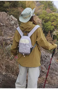 Detailed view of a stylish lavender outdoor hiking backpack worn by a model trekking