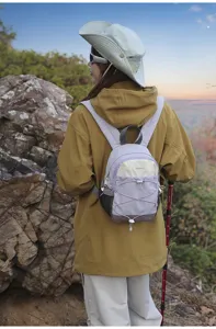 Back view of a purple color-blocked small outdoor backpack worn by a female hiker in nature