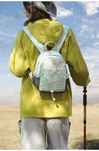 Rear view of a woman wearing a color-block mini hiking backpack in an outdoor setting